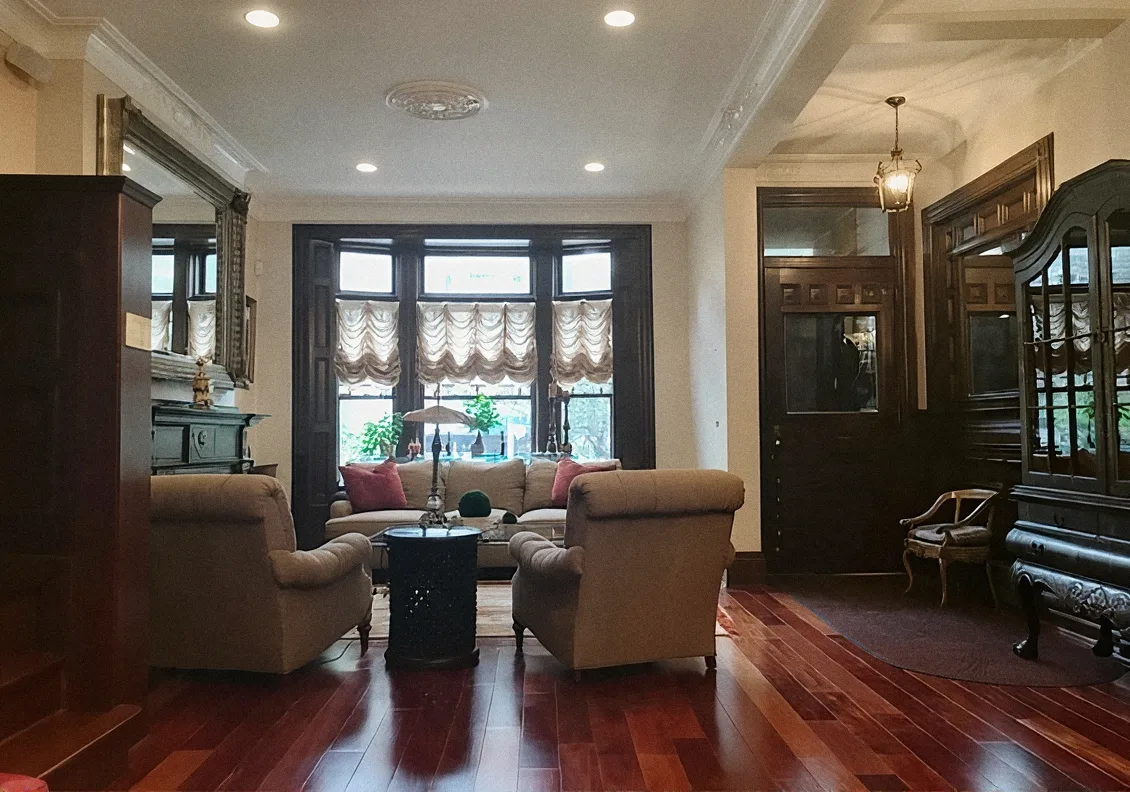 Living room after the remodel, with a bay window, dark wood trim and cherry floors