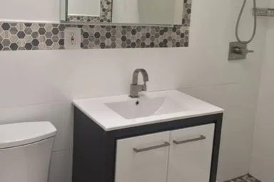 New vanity and mirror framed in hexagon tile
