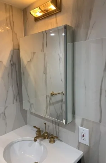 Marble shower wall with a brass sconce